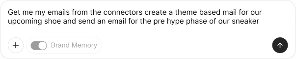 A chat input pill reading 'Get me my emails from the connectors, create a theme-based mail for our upcoming shoe and send an email for the pre-hype phase of our sneaker' with a + attach button, Brand Memory toggle, and a send arrow.